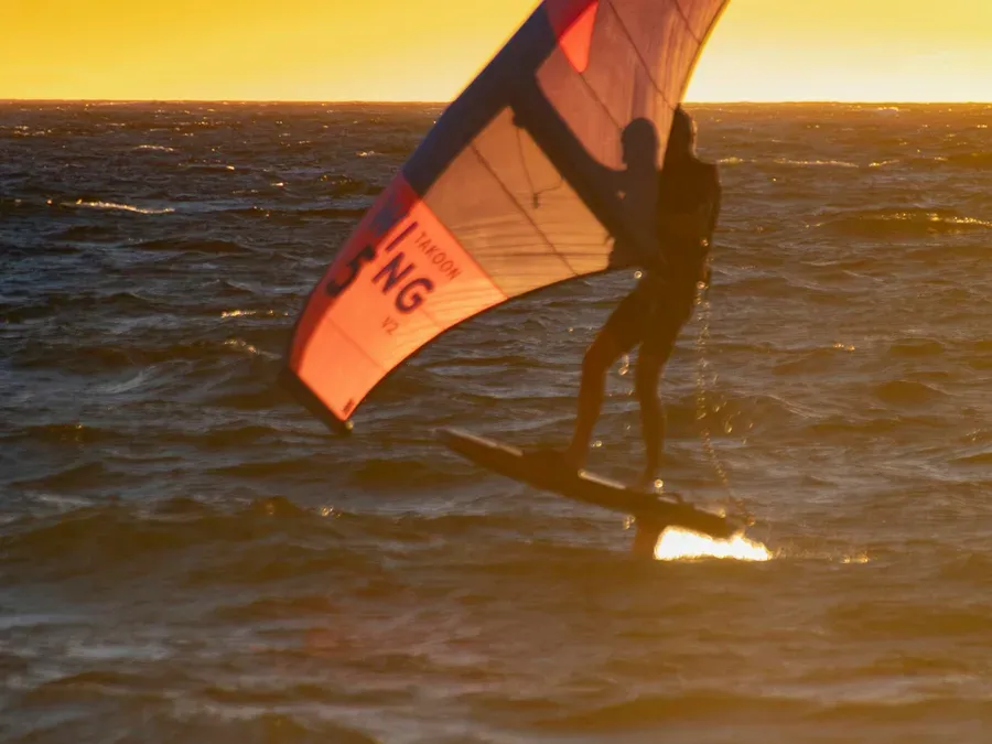 Wing foiler sur la Mediterranee au coucher du soleil, Hyeres France